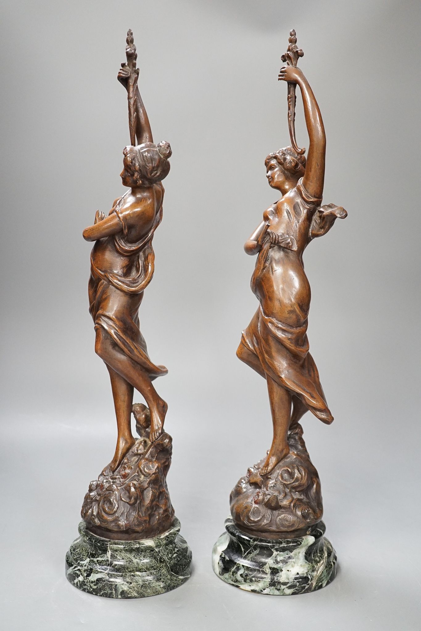A pair of bronze female dancers, on marble plinths, 47cm
